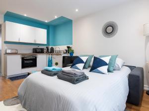 1 dormitorio con 1 cama blanca grande y paredes azules en LE VALLES - HYPERCENTRE PARKING GRATUIT WiFi NETFLIX AMAZON PRIME, en Villeurbanne