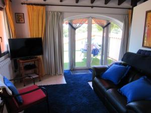 a living room with a couch and a large window at Villa Mimosa in Moraira
