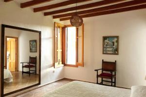 ein Schlafzimmer mit einem Spiegel und einem Stuhl in einem Zimmer in der Unterkunft Casa El Higueral in Mecina Alfahar