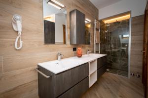 a bathroom with a sink and a shower and a phone at Casa Viola Lodge in Valdidentro +49 photos