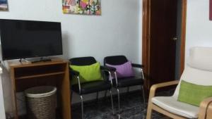 Habitación con 3 sillas y almohadas coloridas. en Casa Rural La Yedra, en Níjar