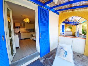 a room with a blue door and a kitchen at Appartamento La Perla del Golfo 2 in Capoliveri