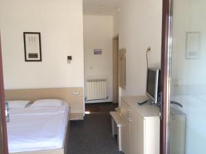 a hotel room with a bed and a television at Vila Patricia in Eforie Nord