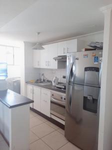 a kitchen with a stainless steel refrigerator and a stove at Apartamento NEO vista al mar in Iquique