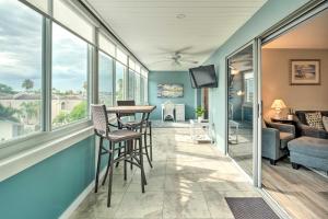 uma sala de estar com uma mesa, cadeiras e janelas em Resort-Style Siesta Key Condo Walk to Beach! em Siesta Key