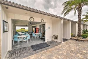 a patio with a table and chairs and a clock at Walk to Beach Resort-Style Siesta Key Condo! in Siesta Key