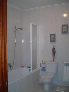 a bathroom with a toilet and a tub and a shower at Tranquilidad en helguera in Helguera