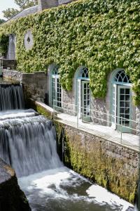 a waterfall in front of a building with ivy at Cliff at Lyons in Celbridge