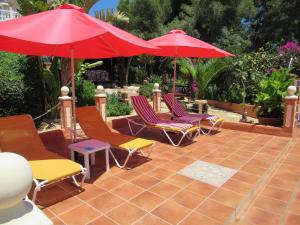 a group of chairs and umbrellas on a patio at Villa Mimosa in Moraira