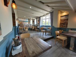 滨海韦斯顿South Sands Hotel的餐厅配有木桌和椅子