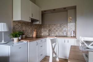 a kitchen with white cabinets and a wooden table at Apartament Konda in Białka Tatrzańska