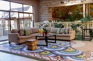 soggiorno con divani e tavolo su un tappeto di Bloem Spa Hotel & Conference a Bloemfontein