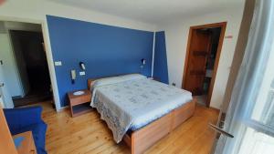 a blue bedroom with a bed and a blue wall at ALBERGO BELVEDERE in Orasso +20 photos