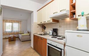 uma cozinha com um frigorífico branco e um fogão forno superior em Sweet em Marinići