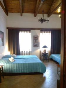 1 dormitorio con 2 camas y 2 ventanas en Villa Belmar Self-Catered Apartments, en Eretria