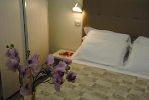 a bedroom with a bed with purple flowers on it at Hotel Tenerife in Riccione