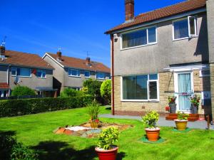 einen Hof mit Topfpflanzen vor einem Haus in der Unterkunft 216 GLYN EIDDEW (IVY VALE) in Cardiff