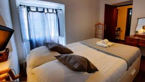 a bedroom with two beds with pillows and a mirror at Casa do Lêntejo - Casas de Taipa in São Pedro do Corval