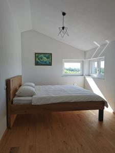 een slaapkamer met een bed in een kamer met witte muren bij Apartments Casa Tijola in Sečovlje