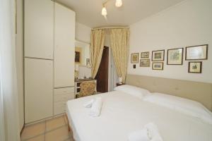 una camera bianca con letto bianco e specchio di Appartamento Balander - Gardagate a Sirmione