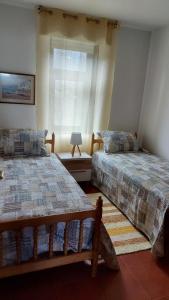 sypialnia z 2 łóżkami i oknem w obiekcie Estupendo apartamento en San Vicente do Mar O Grove w mieście San Vicente do Mar