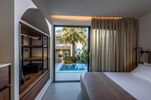 een slaapkamer met een bed en uitzicht op een zwembad bij Soleil Rooms and Suites in Stalida