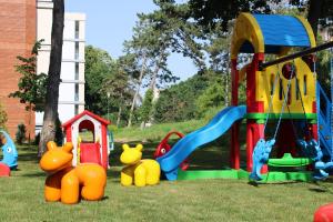 a playground with colorful play equipment in the grass at Spring Holiday Resort in Neptun