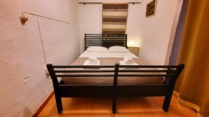 Un pequeño dormitorio con una cama con toallas. en Casa do Compadre - Casas de Taipa, en São Pedro do Corval