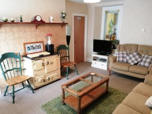 a living room with a couch and a coffee table at Causeway Coast Carrivcashel Holiday Home in Ballymoney