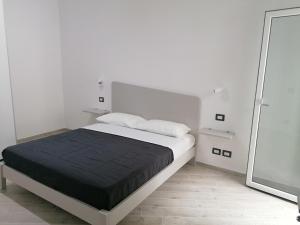 a white bedroom with a large bed and a mirror at Vasto in centro in Vasto