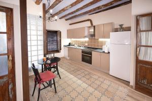 a kitchen with a table and a white refrigerator at Casa l'Escorretger in Calaceite