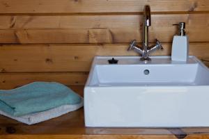 baño con lavabo blanco y toalla en Portugal Nature Lodge, en São Luis