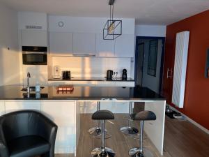 a kitchen with a counter and two bar stools at luxestudio - zeezicht - groot terras - zwembad in Ostend