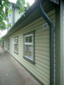 a green building with a sign on the side of it at Rönne Majutus in Pärnu