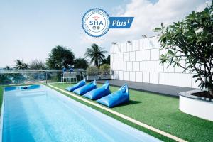 a swimming pool with blue pillows next to a building at BearPacker Patong Hostel in Patong Beach
