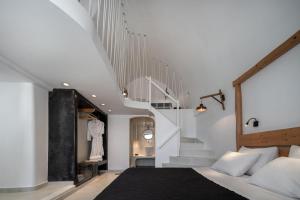 a bedroom with a bed and a staircase at Kasimatis by La Perla - Adults Only in Imerovigli