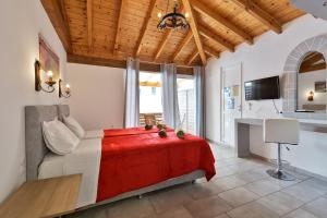 a bedroom with a large bed with a red blanket at Fotini Studios in Paleokastritsa