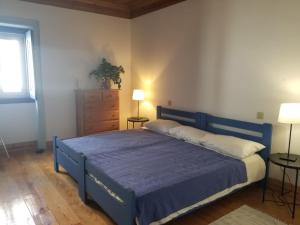 a bedroom with a blue bed and a dresser at Azoia 10 - Casas de Campo & Hostel in Azoia de Baixo
