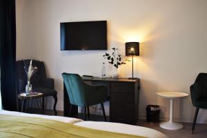 a hotel room with a desk and a tv on the wall at Hotel zum See garni in Dießen am Ammersee