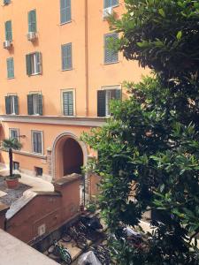 een oranje gebouw met een boog voor een boom bij Mc - Piazza Mancini in Rome