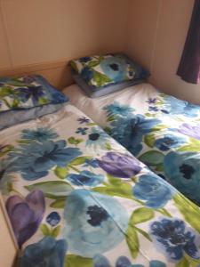 a bed with a floral comforter on top of it at TP52 in Skegness