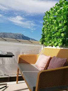 a patio with a table and chairs and a bush at Apartman LUCIJA in Korčula