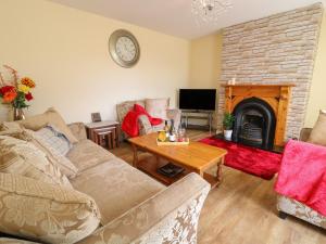 a living room with a couch and a fireplace at Slieve Gallion Cottage in Magherafelt