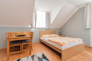 a bedroom with a bed and a desk and a window at Domki i pokoje POD KOGUTEM - kwatery prywatne in Stegna