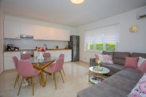 - un salon avec un canapé et une table avec des chaises roses dans l'établissement Luxury Villa Vibrass, à Split