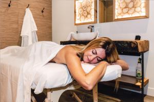 Una mujer acostada en una cama en un salón en Bel Air Tremblant Hotel & Residences en Mont-Tremblant