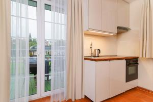a kitchen with white cabinets and a large window at Villa Fenix in Ustronie Morskie