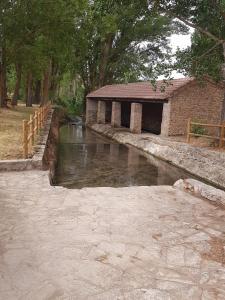 a building next to a river with a bridge at Casa Rural San Miguel in Saúca +35 photos