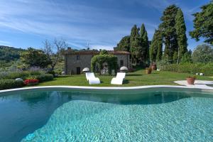 una piscina al aire libre frente a una casa en Charming house Loretta, with panoramic swimming pool, en Nievole