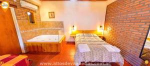 a room with two beds and a bath tub at Apart Cabañas Altos de Vaquerias in Valle Hermoso